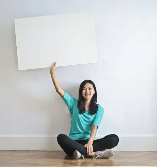 A-lady-holding-up-an-empty-sign-before-writing-down-how-to-settle-an-estate. 