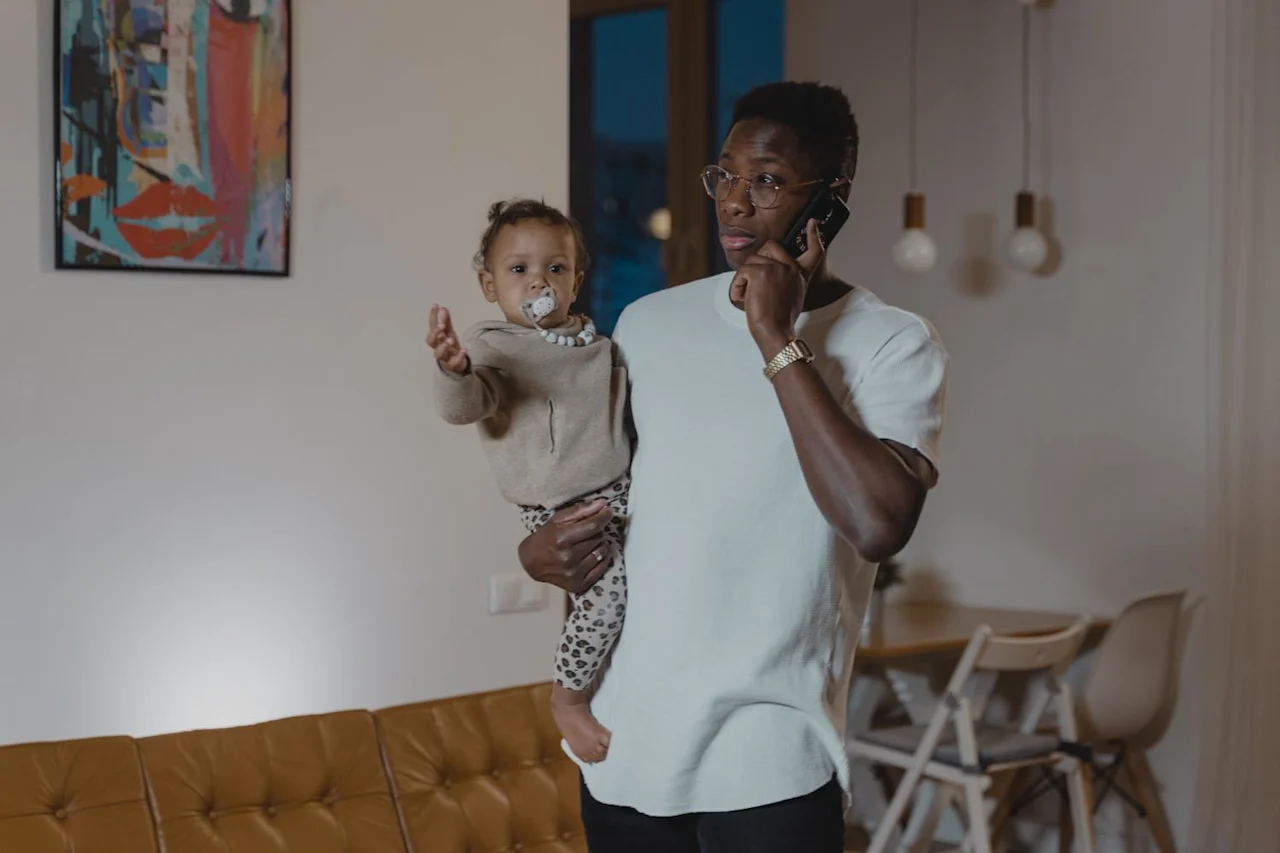 Man with his kid talking on phone about estate and cryptocurrency planning vs financial planning.