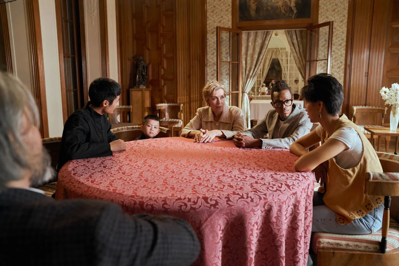 Family sitting around a table for the reading of the Will.