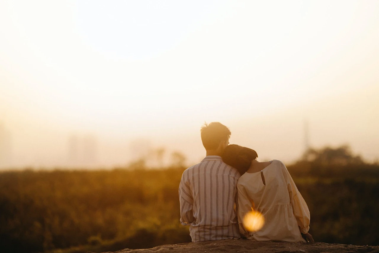 Couple looking at the sunset mourning a loss.